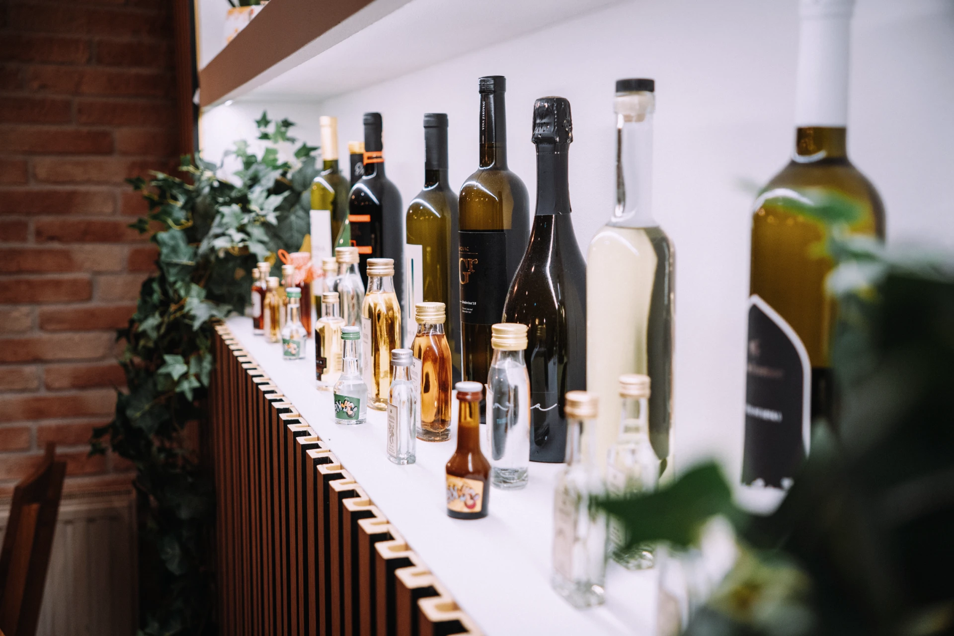 Polica sa vlastitim osvjetljenjem sa kvalitetnim vinima i likerima u maloj sali