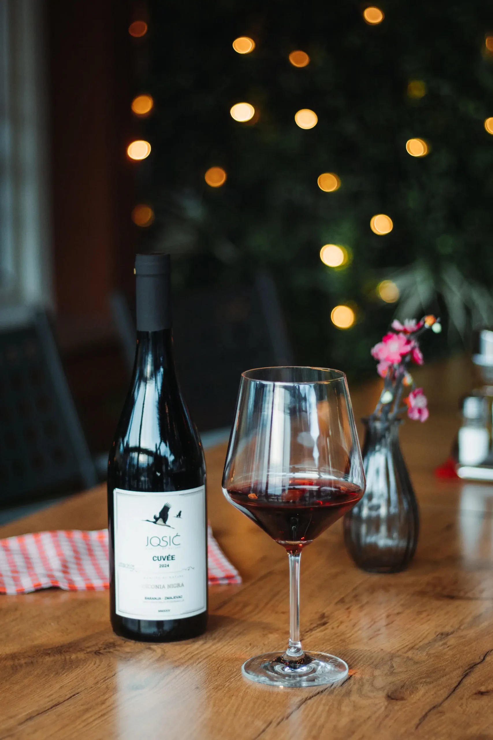 Otvorena butelja vrhunskog crnog vina i lijepa polunatočena čaša